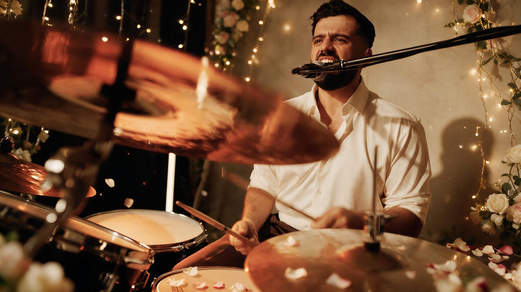 Live drummer performing at a wedding surrounded by flowers